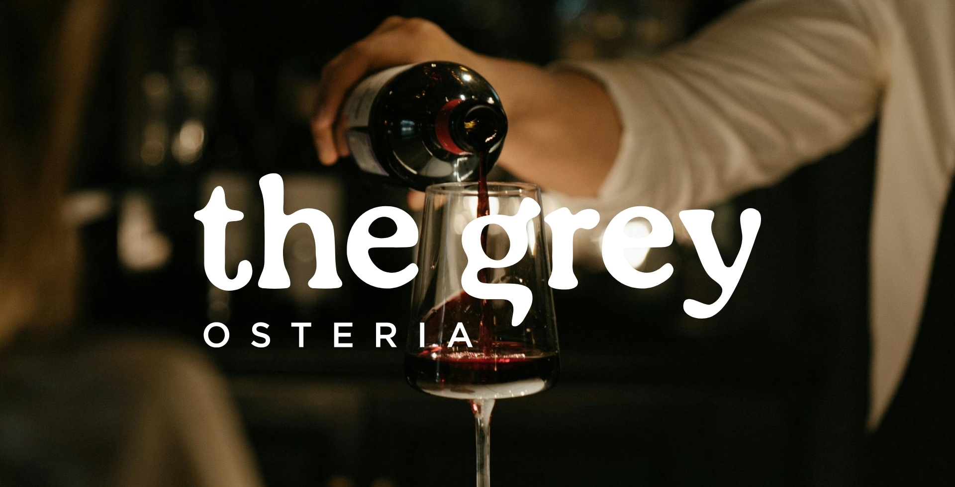 a professional pouring a glass of red wine